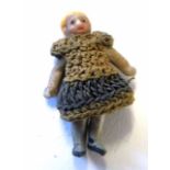 Miniature doll wearing a woolen dress