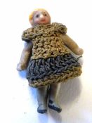 Miniature doll wearing a woolen dress
