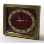 Travelling clock, the brass chased enamel with oval dial on a red enamel background