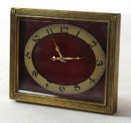 Travelling clock, the brass chased enamel with oval dial on a red enamel background