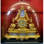 19th century gilt brass clock in Louis XV style, under a large glass dome, the gilt face with blue