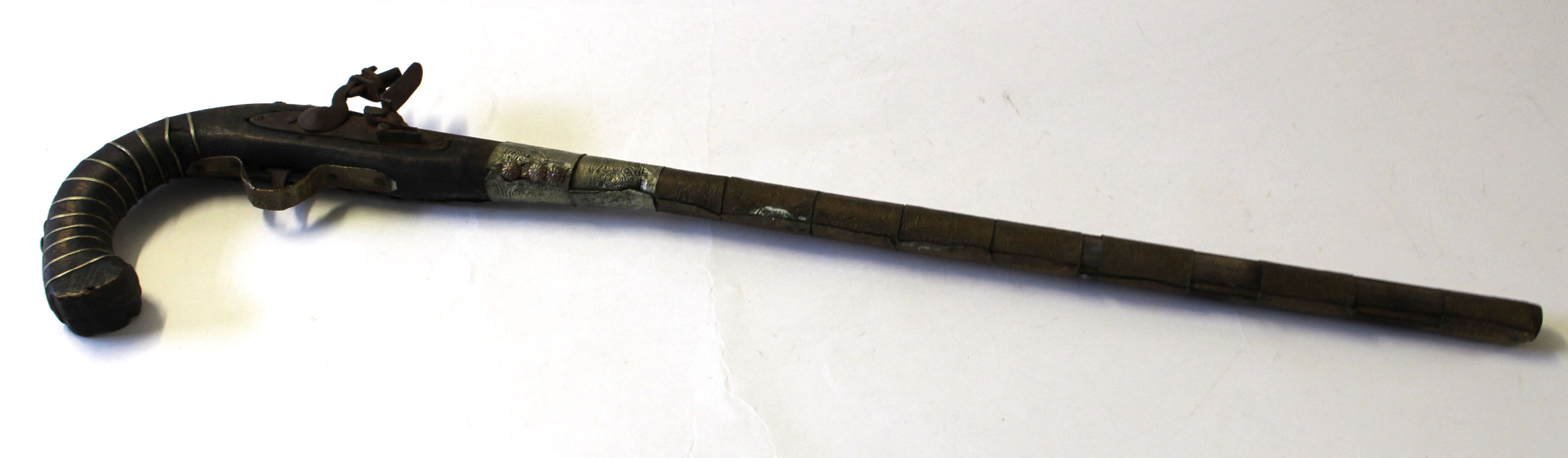 19th century decorative Far Eastern or Indian pistol, the barrel bound with impressed brass,