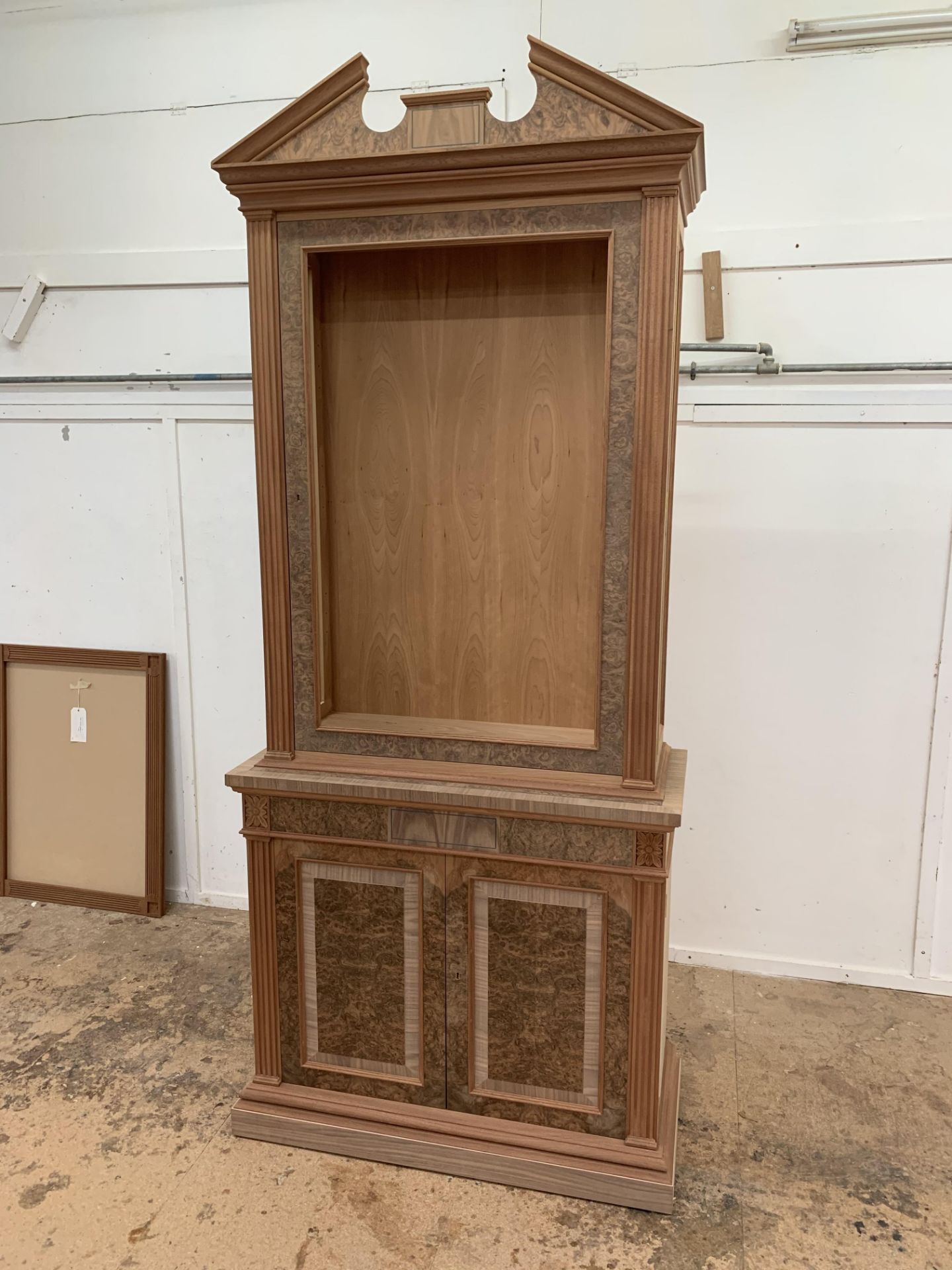 Two-door tall Bookcase, in walnut finish, from the Corinthian range, requires finishing/polishing.
