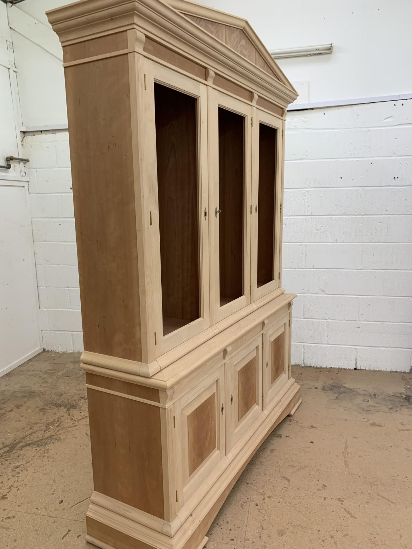 Three door Bookcase, with pediment, from the Trafalgar Cherry range, requires finishing/polishing.