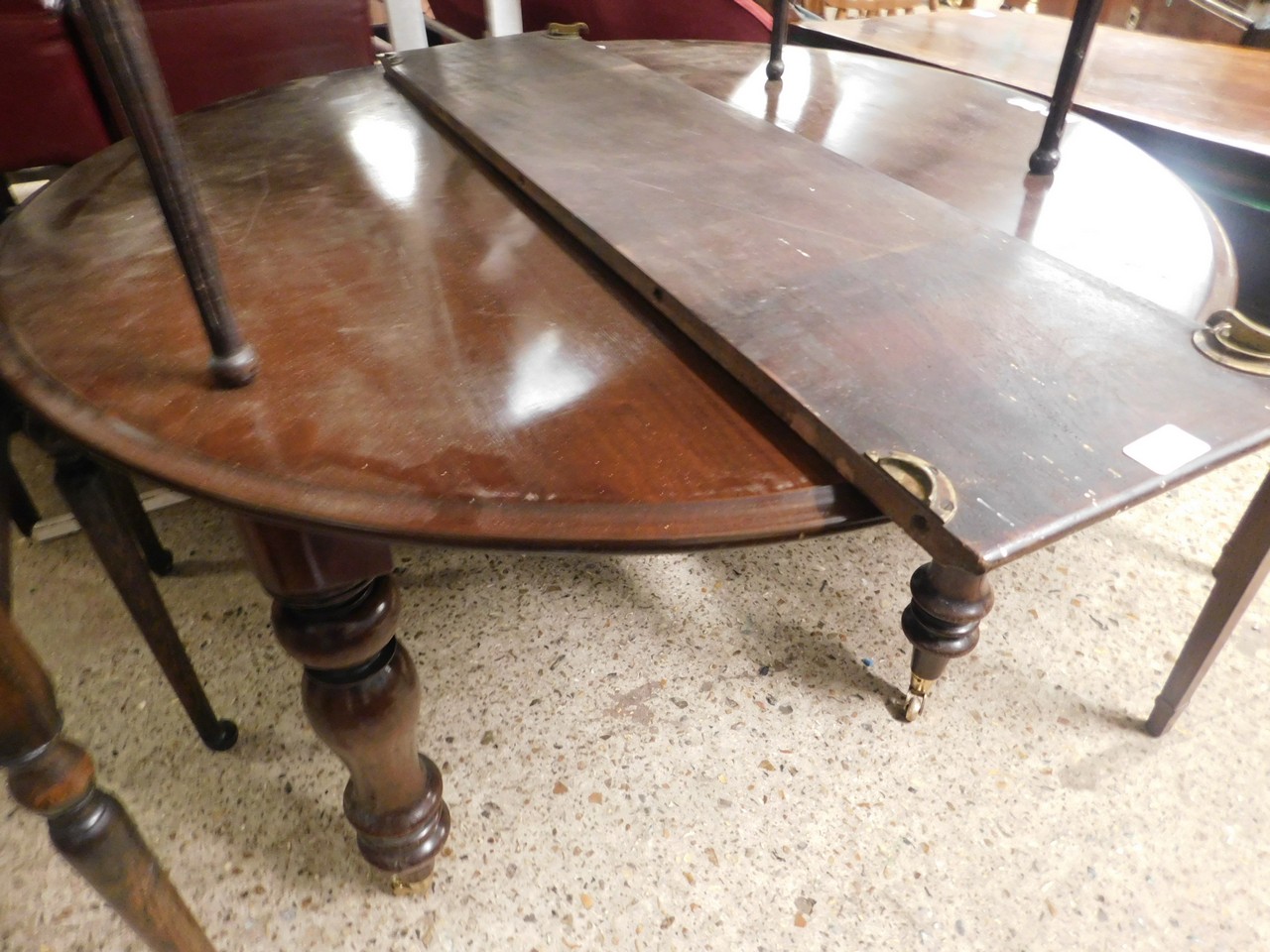 VICTORIAN CIRCULAR EXTENDING DINING TABLE ON TURNED LEGS RAISED ON BRASS CASTERS (WITH ONE LEAF)