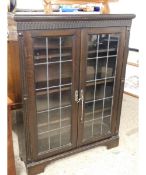 MID-20TH CENTURY OAK FRAMED BOOKCASE WITH TWO LEADED AND GLAZED DOORS AND CARVED DETAIL