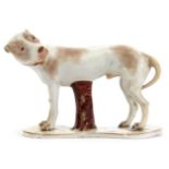 18th century model of a hound with his head turned looking over his shoulder, the hound on a