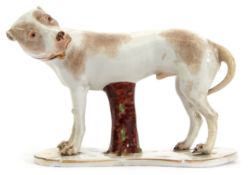 18th century model of a hound with his head turned looking over his shoulder, the hound on a