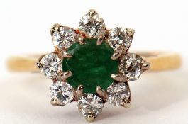 18ct gold emerald and diamond cluster ring, the circular shaped emerald multi-clawed set within a