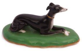 19th century Copeland & Garrett model of a greyhound, the black hound seated on an oval green