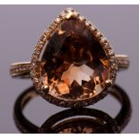 Modern champagne topaz and diamond ring, the pear cut champagne topaz approx 7.43ct, set within a