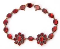Georgian style 9kt stamped garnet bracelet, a design with two flowerheads and 14 oval shaped