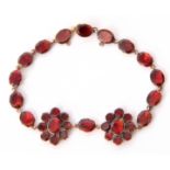 Georgian style 9kt stamped garnet bracelet, a design with two flowerheads and 14 oval shaped