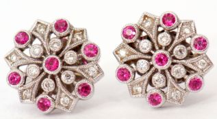 Pair of 18ct white gold and ruby diamond cluster earrings, the flowerhead design features seven