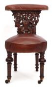 Mid/late Victorian carved oak and brown leather upholstered "cockfighting" chair, the back panel