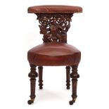 Mid/late Victorian carved oak and brown leather upholstered "cockfighting" chair, the back panel