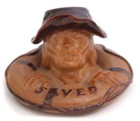 Unusual Royal Doulton match striker modelled as a man clinging to a lifeboat with the legend "