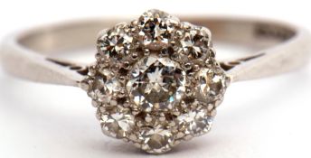 Precious metal and diamond cluster ring, the principal diamond 0.20ct approx surrounded by eight