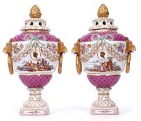 Pair of Continental porcelain urns with lion mask handles and reticulated covers, both decorated