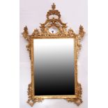 Large gilded overmantel mirror of rectangular form, C scroll surround and further floral detail