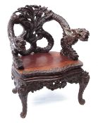 Oriental hardwood throne type tub chair, arched back and two arms terminating in griffons over a