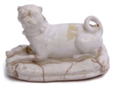 Bow porcelain figure of a pug seated on a cushioned base with tassels to corner (cracks), 12cm long