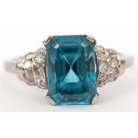 Precious metal blue zircon and diamond ring, the emerald cut zircon raised between small diamond set