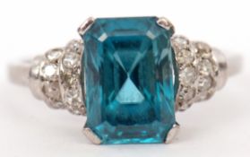 Precious metal blue zircon and diamond ring, the emerald cut zircon raised between small diamond set