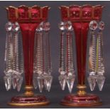 Pair of ruby coloured glass table lustres with typical gilded rim and gilded star decoration to
