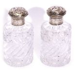 Pair of Victorian cut glass cylindrical dressing table scent bottles with figure and scroll embossed