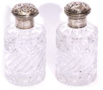 Pair of Victorian cut glass cylindrical dressing table scent bottles with figure and scroll embossed
