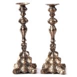 Pair of Continental rococo style white metal candlesticks on shaped square bases with knopped