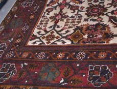20th century large Indian carpet, a central panel of geometric floral decoration within a multi-gull