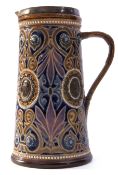 Doulton Lambeth lemonade jug with an incised design in blue and brown with medallions of classical