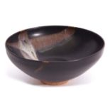 Unusual Oriental pottery bowl with a Tenmoku type glaze and streaked design to interior, 15cm diam