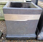 Black painted composition garden planter of square form with a stepped base, 35cm high