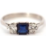 Precious metal sapphire and diamond three stone ring, the square cut sapphire flanked between two