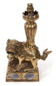 Chinese gilt bronze lamp, modelled as a temple dog on a rectangular base with lamp formed as a lotu