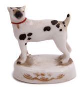 Mid-19th century English porcelain model of a dog on an oval base with brown markings, 5cm long