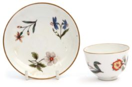 Mid-18th century Meissen tea bowl and saucer decorated with scattered Holzschnittblumen, the