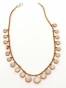 Moonstone necklace, design is a line of graduated circular cut moonstone drops, each set in cut down