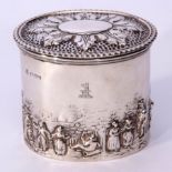 Edwardian oval tea caddy, the body embossed with a continuous village scene with numerous figures,