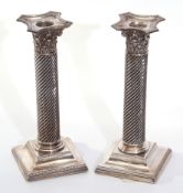 Pair of Victorian silver encased candlesticks with loaded sloped and beaded square bases, wrythen