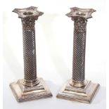 Pair of Victorian silver encased candlesticks with loaded sloped and beaded square bases, wrythen