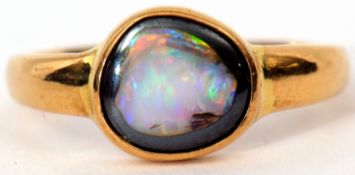 Modern opal doublet ring, bezel set in a plain polished yellow metal mount, 6.6gms gross weight,