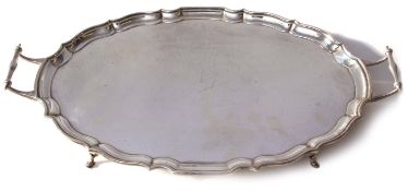 George V shaped oval tea tray with pie-crust edge and two side handles, plain centre, raised on four