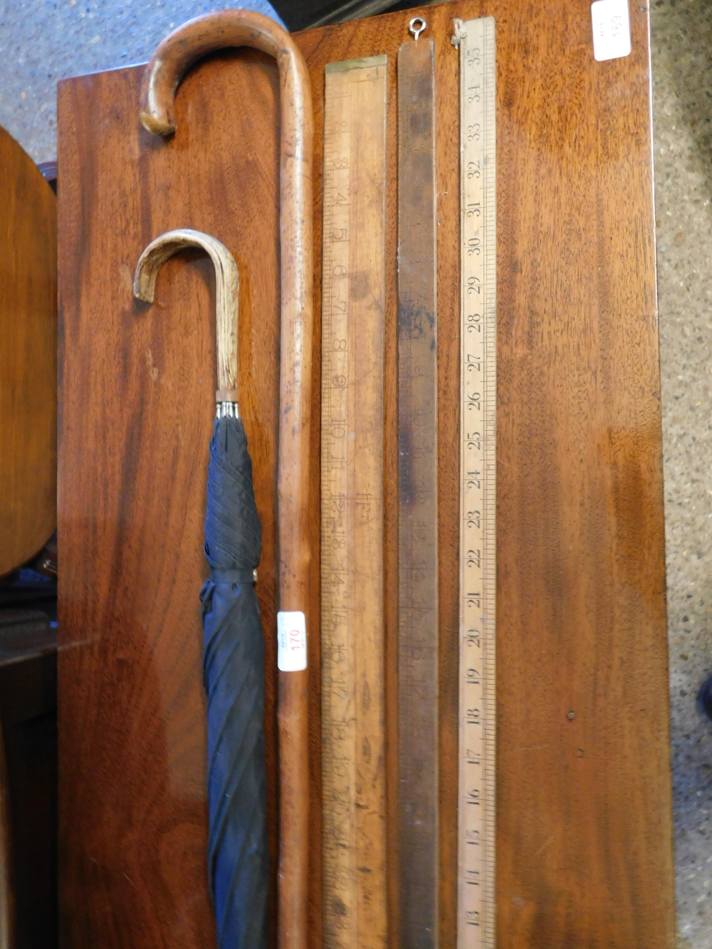 TWO WOODEN RULERS, AN UMBRELLA AND A WALKING STICK