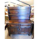 DARK STAINED OAK SIDEBOARD OR DRESSING WITH TWO FIXED SHELVES AND PANELLED BACK, THE BASE WITH TWO
