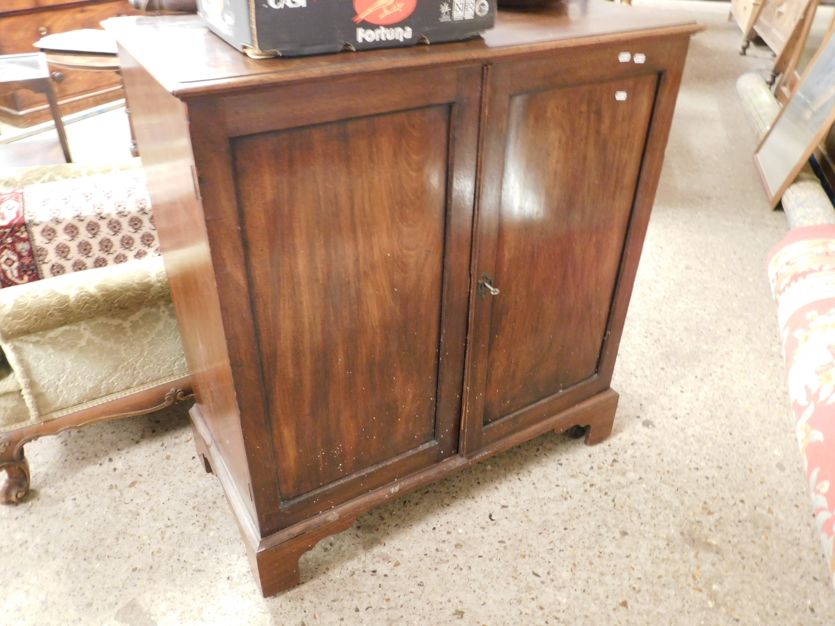 MAHOGANY FRAMED MUSIC CUPBOARD WITH TWO DOORS RAISED ON BRACKET FEET