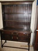 OAK FRAMED DRESSER, THE TOP FITTED WITH TWO FIXED SHELVES AND PANELLED BACK, THE BASE WITH TWO